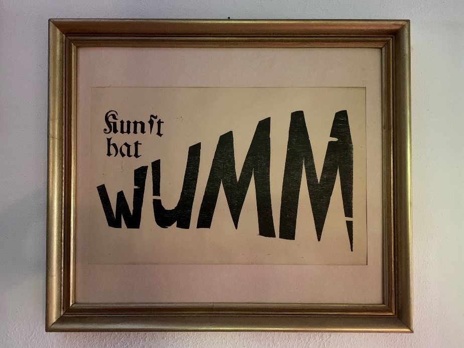 Photo of a graphic writing in a golden frame. There it says: Art has Wumm