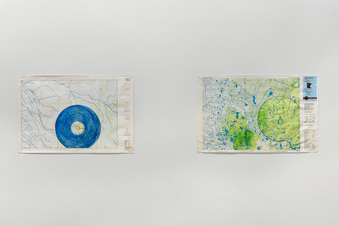 Zwei Landkarten an einer Wand. Übermalt mit Kreisformen in Blau und Grüngelb.