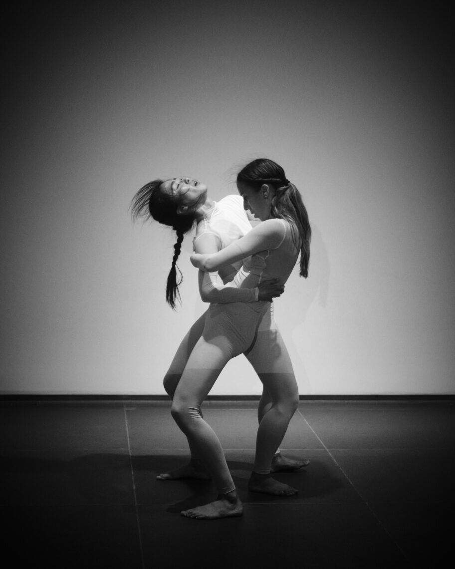 Schwarz-weiß Fotografie von zwei Frauen, die sich tanzend im Arm halten. Eine wirft den Kopf nach hinten 