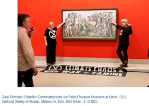 Zwei Extinction Rebellion Demonstrierende vor Pablo Picassos Massacre in Korea von 1951, in der National Gallery of Victoria in Melbourne. Sie haben je eine Hand auf dem Gemälde abgelegt, das an einer knallroten Wand hängt.